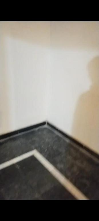 a room with a white wall and a black floor at Hayatabad Heights1 in Peshawar