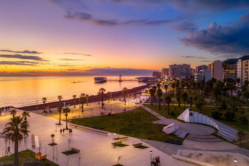 a view of a city with the ocean and a sunset at Beachfront Central Boutique Apartments in Durrës