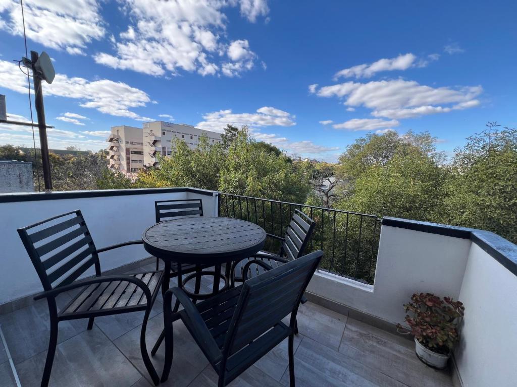 a patio with a table and chairs on a balcony at Nduna Legacy Apartment in Harare