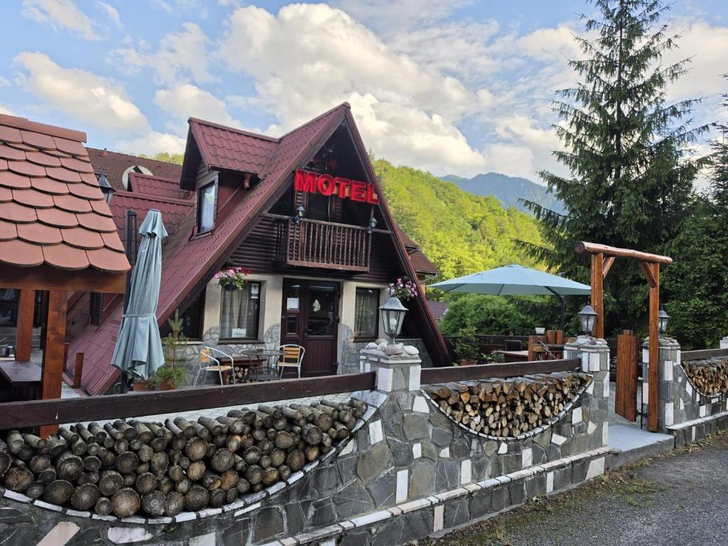 a building with a bunch of logs in front of it at Motel “La Butuci” in Timisul de Jos
