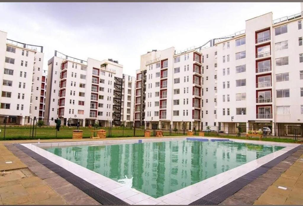 a swimming pool in front of some apartment buildings at Ngong Road Luxe Studio in Nairobi