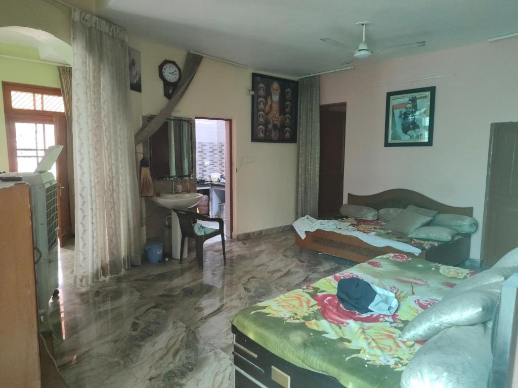 a living room with a bed and a tv in it at Bali cottage in Jammu