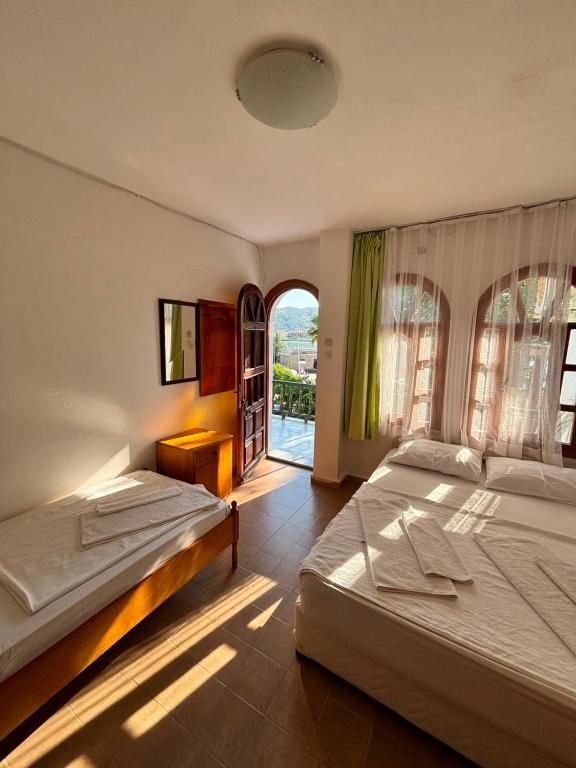 a bedroom with two beds and a window at Kalimerhaba Motel Restaurant in Gokceada Town