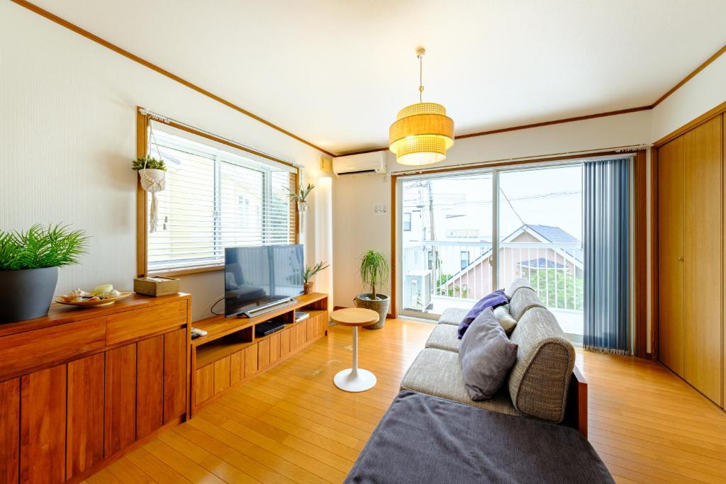 a living room with a couch and a television at Hale Kai Akiya in Yokosuka