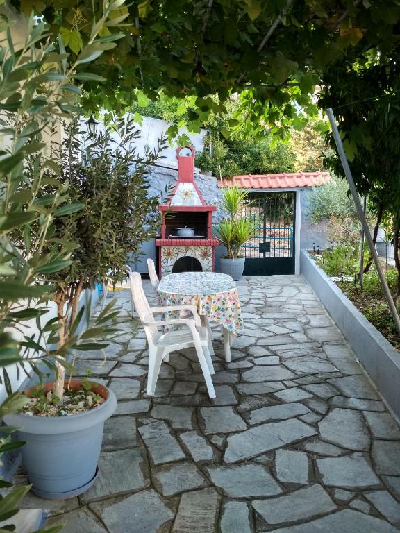a patio with a table and a fire place at Vasilis Garden House in Kavála