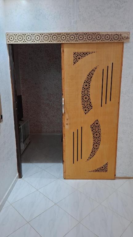 a wooden door with a design on it at Belle apt près de la mer in Tangier