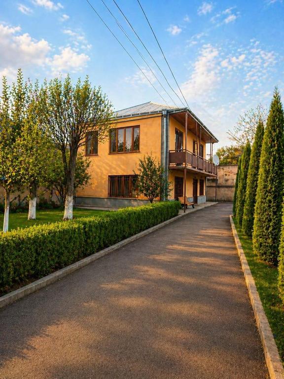 a large yellow house with a driveway at Большой дом в Степанаване in Stepʼanavan