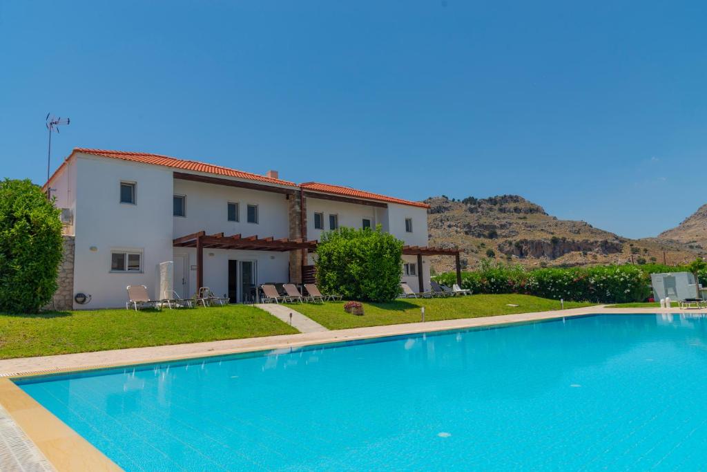 a large swimming pool in front of a house at Villa Kadrina in Kolymbia