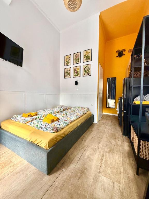 a bedroom with a bed and a tv on the wall at BBB Parkside Studio city center in Budapest