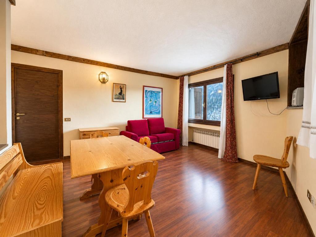 a living room with a table and a red couch at Hostdomus - B2-01 in Grange Sises