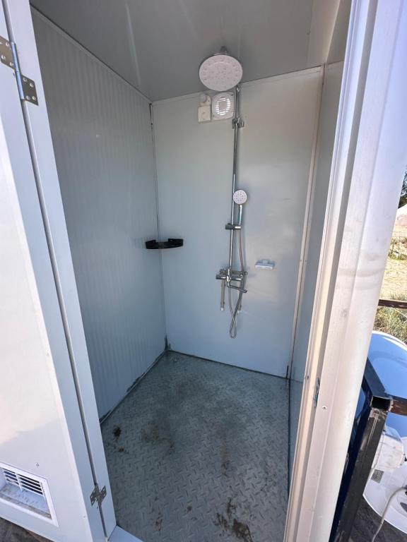 a shower with a glass door in a bathroom at КамбарАта in Tossor
