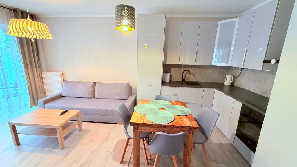 a small living room with a table and a couch at Azymut in Darłowo