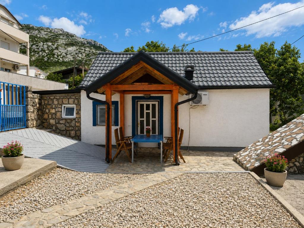 a small house with a blue door and a porch at Holiday home Moni in Karlobag