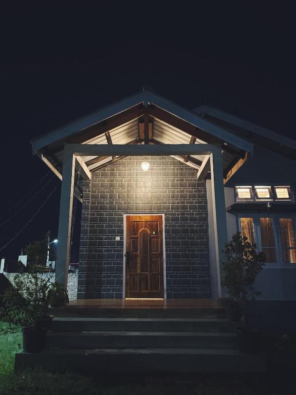 a brick house with a wooden door at night at Arkan Villa in Guwahati