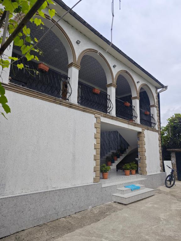 a white building with a balcony with plants on it at House Dea Dea in Chakvi
