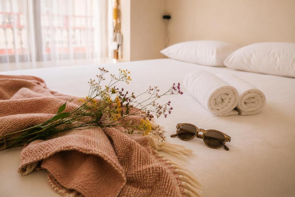 a bed with towels and a pair of glasses on it at Urban Hub in A Coruña