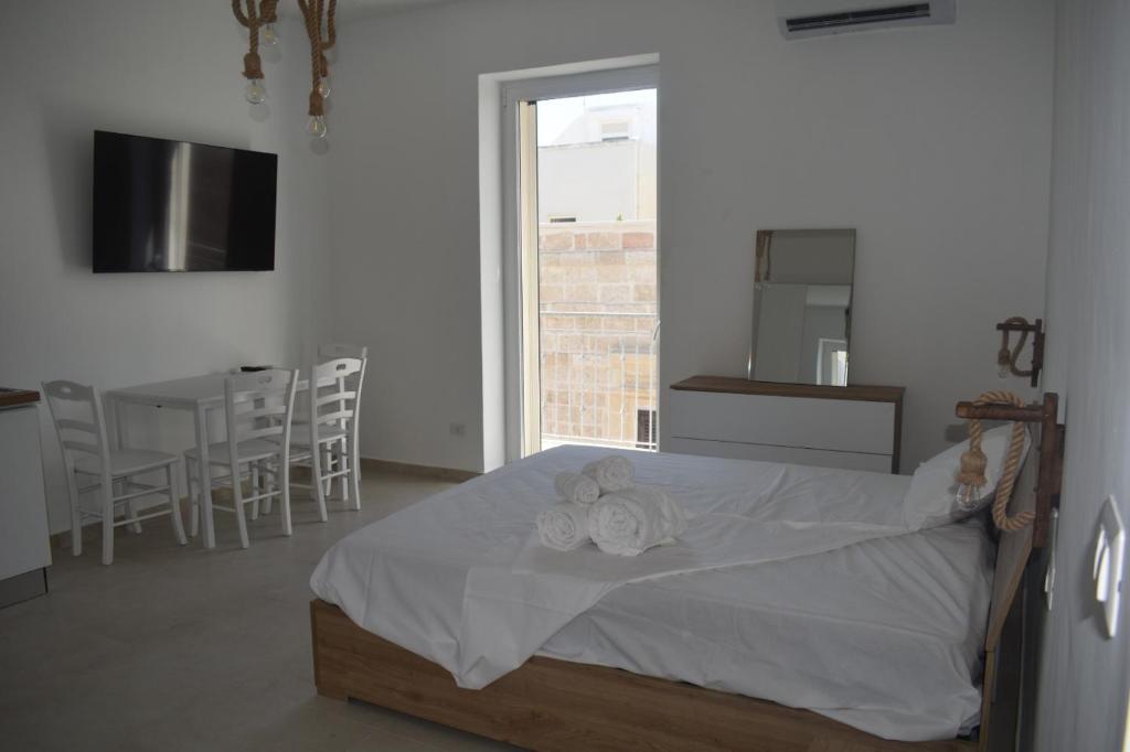a bedroom with a bed and a table and chairs at Terrazza sul Borgo in Polignano a Mare