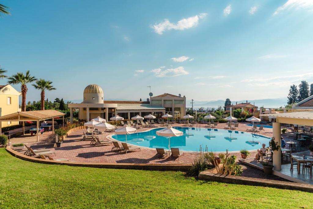 a large pool with tables and umbrellas at a resort at Olympion Village in Kavos