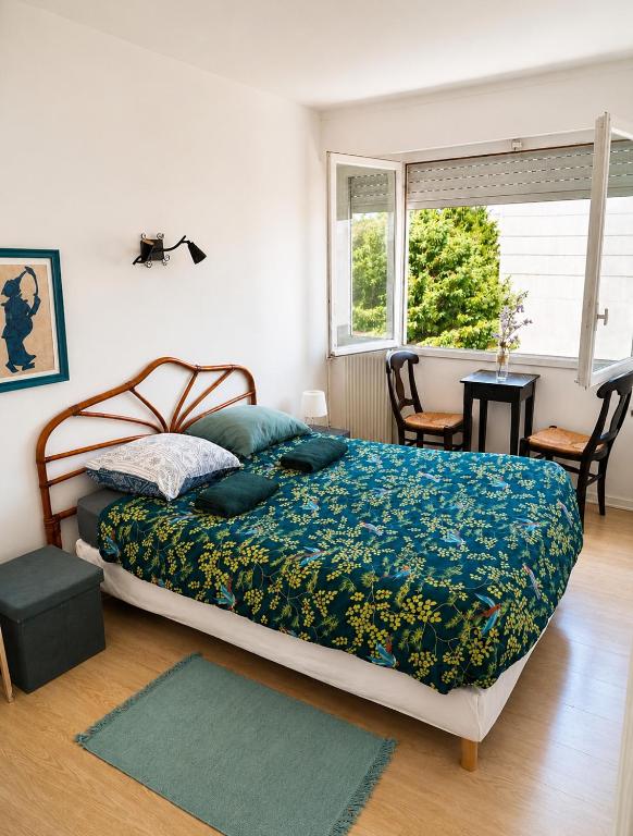 a bedroom with a bed and a table and a window at ANGLET, Chambre privée, QUARTIER CENTRAL in Anglet