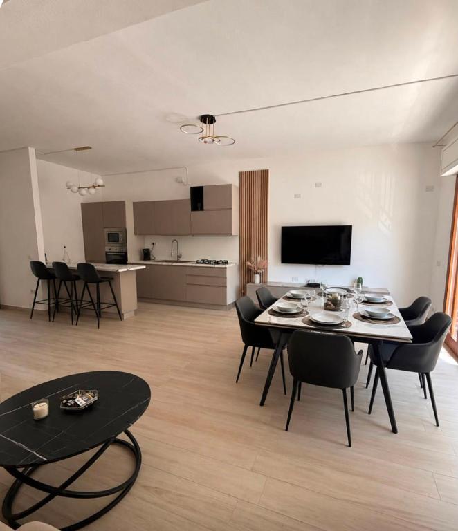 a dining room and living room with a table and chairs at Domus Smeralda in Muravera