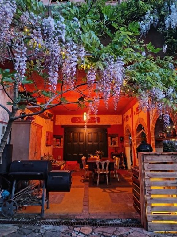 a room with a table and a tree with purple flowers at Krasberry Ježev brlog in Komen