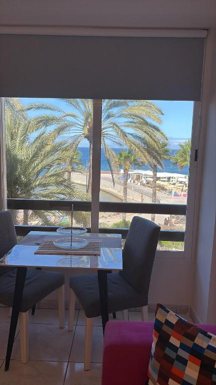 a dining room with a table and a view of the beach at Nice Studio Apartment with Ocean View in Arguineguín