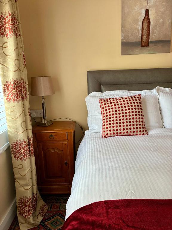 a bedroom with a bed with a red pillow on it at Padoro Lodge in Kildare