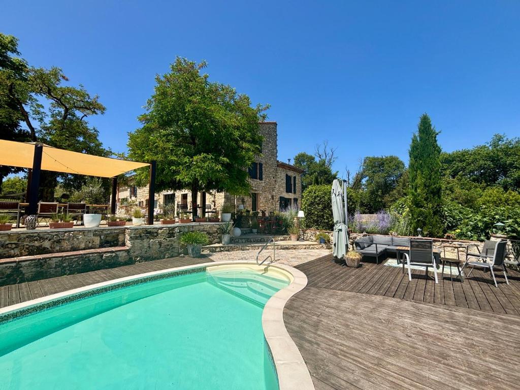 a swimming pool in a yard with a table and chairs at Maison Mûrier in Fayssac