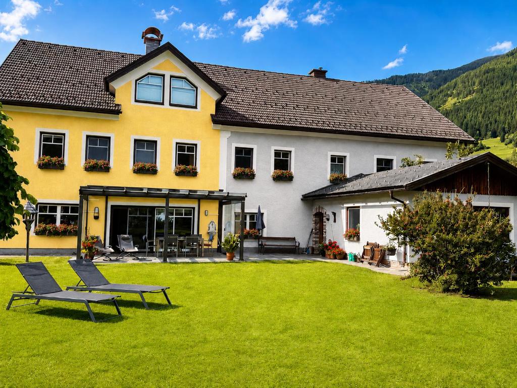 a yellow and white house with a green yard at Apartment Aineckblick in Sankt Michael im Lungau
