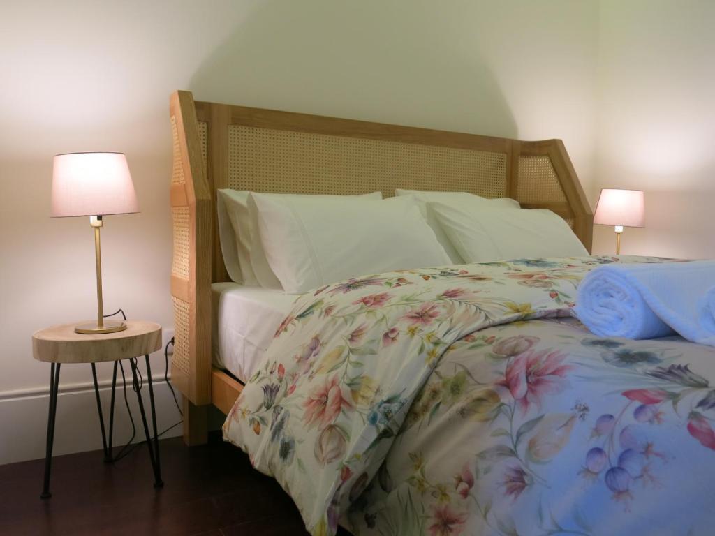 1 dormitorio con 1 cama con colcha de flores y 2 lámparas en Chateau Flores, en Oporto