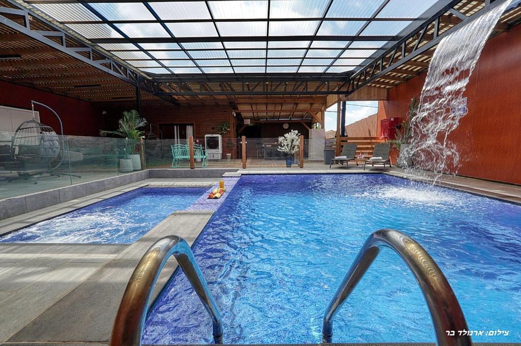 a large swimming pool with a water fountain at Novus Luxury in Yarka