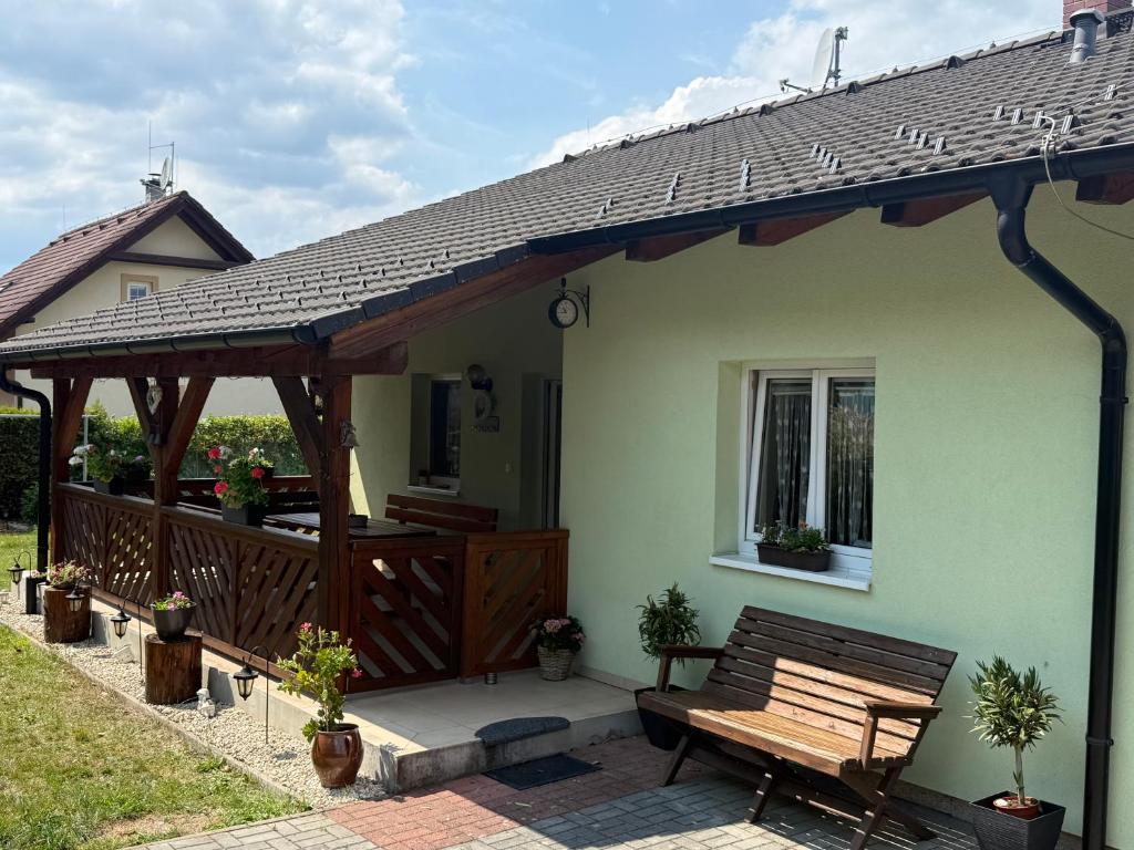 a wooden deck with a bench on a house at Chata U Druhé pískovny in Roudná