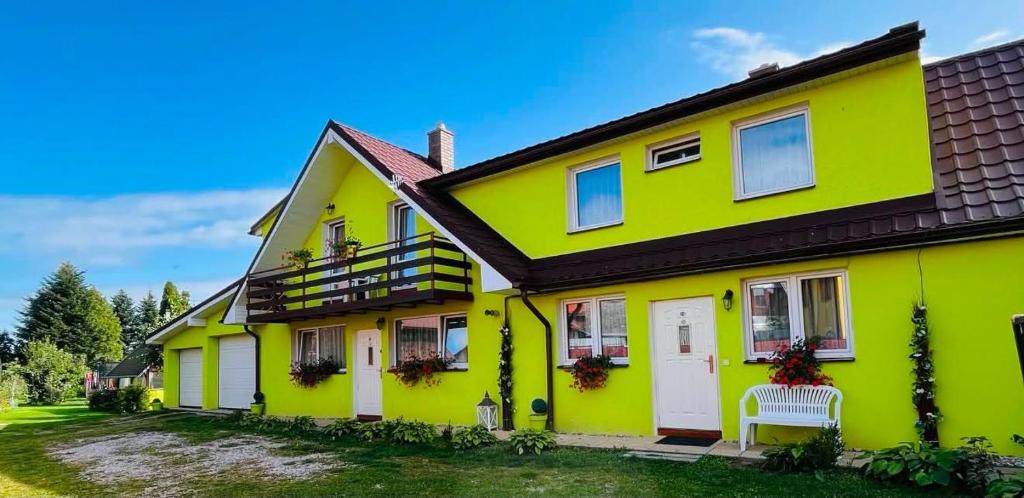 a yellow house with a black roof at Apart-Bungalovy Gitka in Mlynčeky