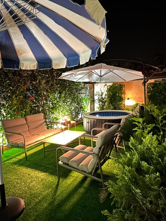 a patio with an umbrella and chairs and a table at Maria Home Reall's in Braga