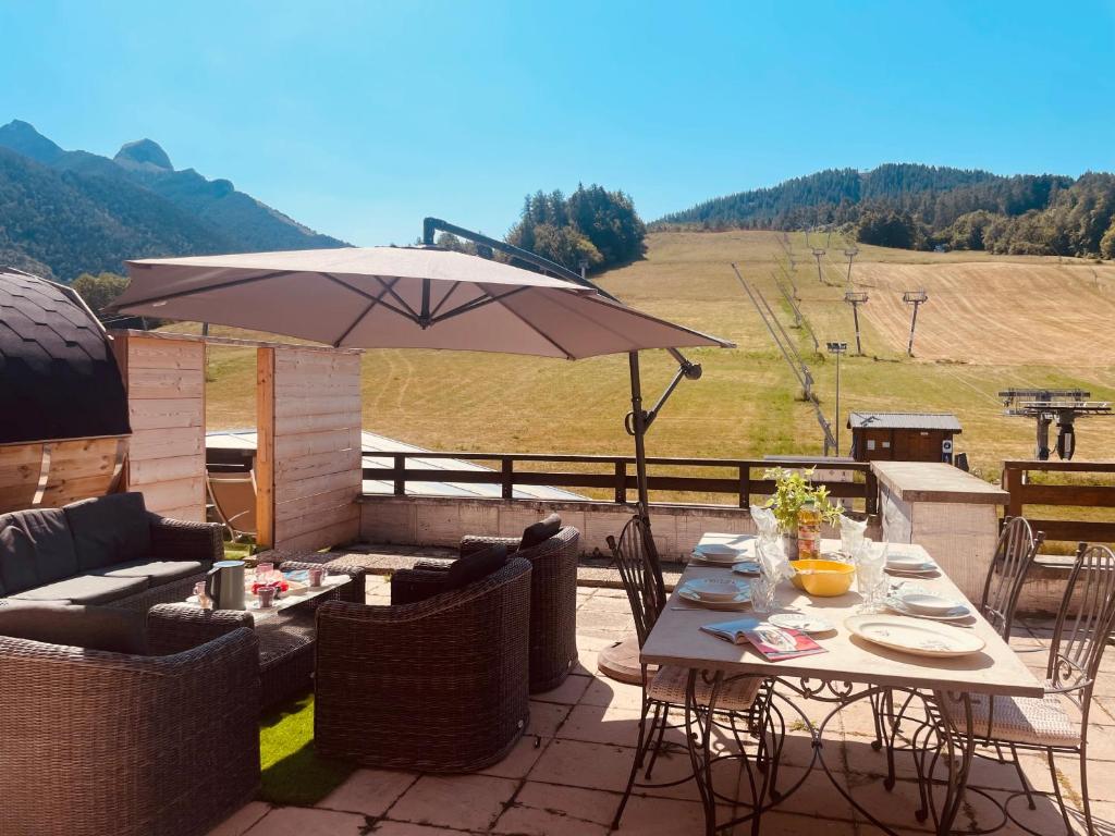 eine Terrasse mit Tisch und Sonnenschirm in der Unterkunft Bambytwo in Ancelle