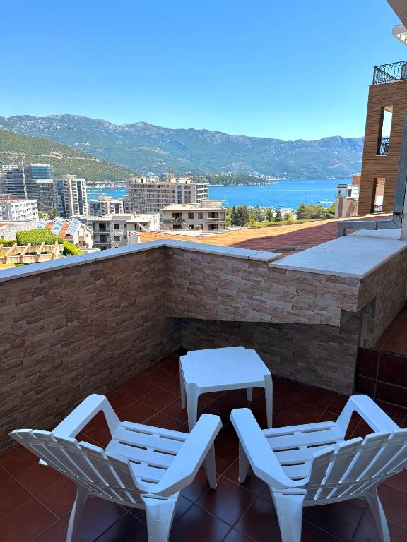 a patio with two chairs and a table on a roof at Apartman sa pogledom na more Budva in Budva