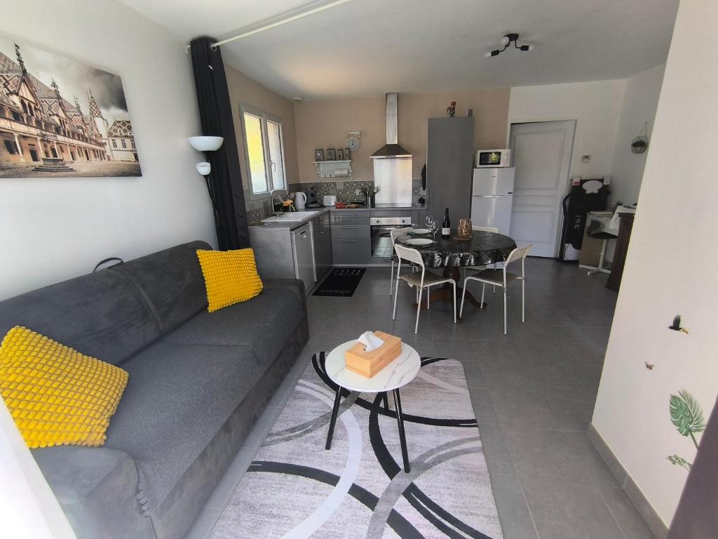 a living room with a couch and a table at Une pause à Magny appartement de 51 m2 proche Beaune et Dijon NETFLIX gratuit in Magny-lès-Villers