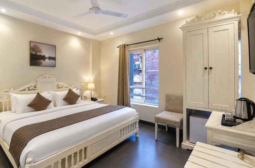 a bedroom with a large white bed and a window at Hotel Pinky Villa-Heritage Boutique Suites Near New Delhi Train station & Connaught place in New Delhi