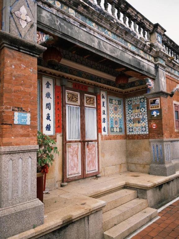 a building with a porch and stairs in front at Kinmen Jinyuge Heritage B&B- Shuitou Minnan Village in Hsia-shih