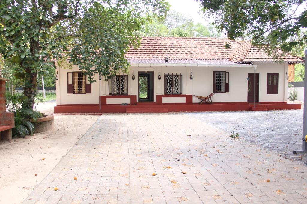 a small house with a red and white facade at Eden Casa in Mararikulam