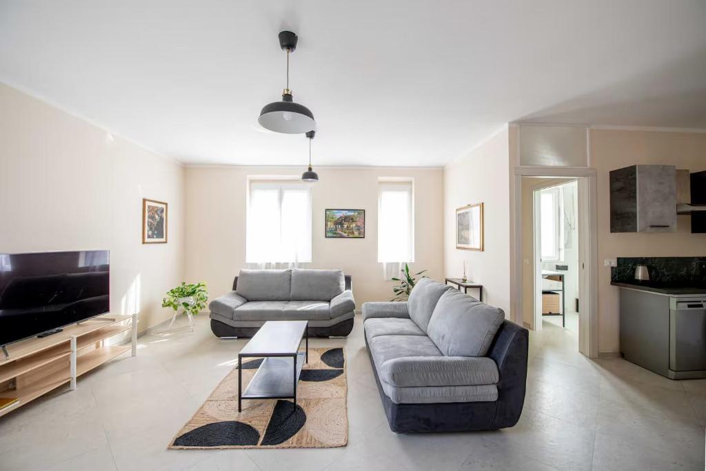 a living room with two couches and a tv at Cetinale Apartments in Cavriglia