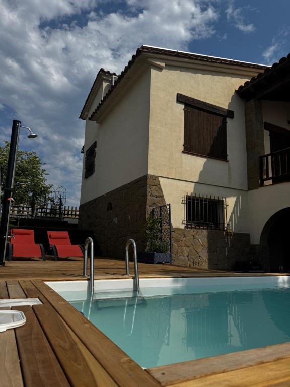 a swimming pool in front of a house at el bosc in Sant Jaume de Llierca
