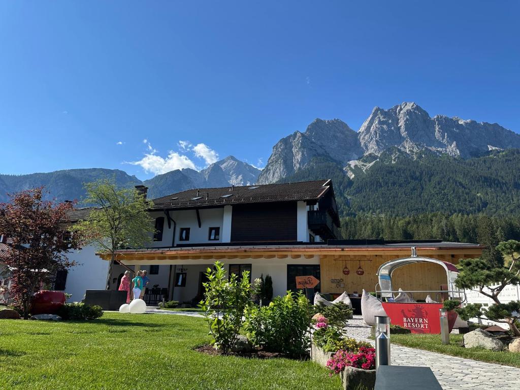 a house with mountains in the background at Bayern Resort Hotel - Adults only - mit Zugspitzblick - Eibsee-Nähe - Wellnessbereich - Naturpool im Sommer in Grainau