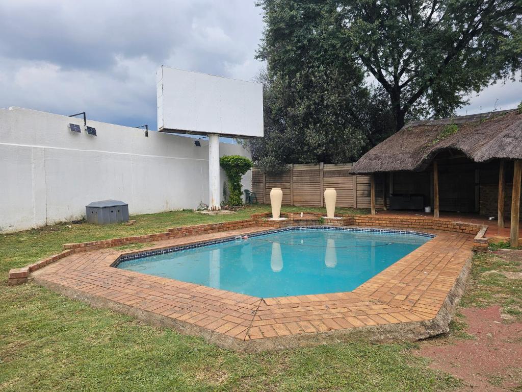 a swimming pool in a yard with a building at Posimuma Guesthouse Boutique in Centurion