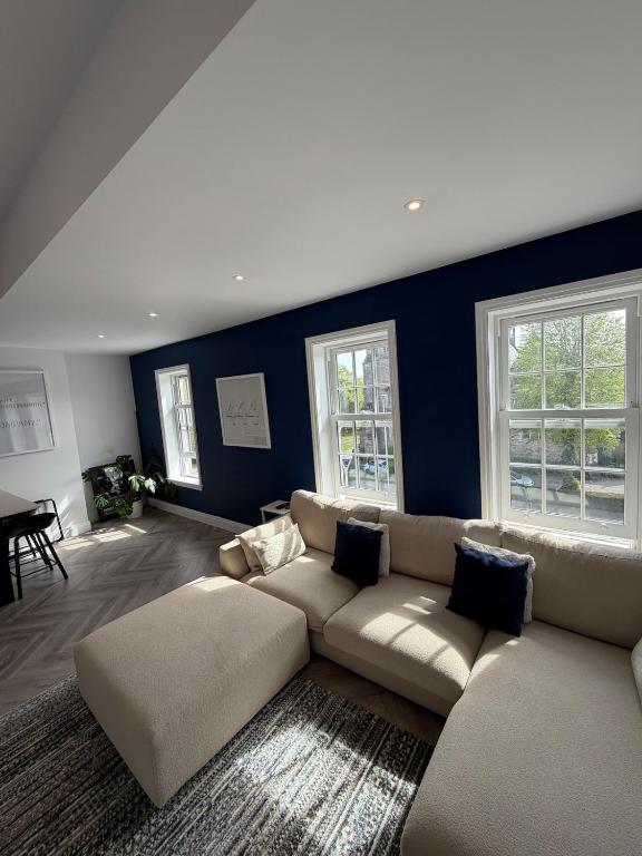 ein Wohnzimmer mit einer Couch und zwei Fenstern in der Unterkunft The Loft, FlatB, Redditch in Redditch