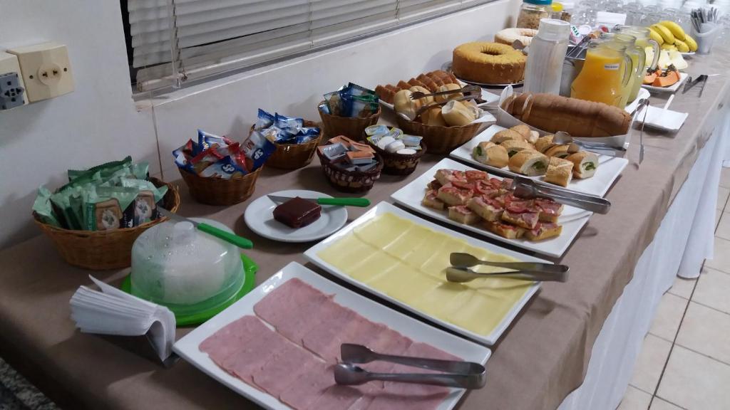 ein Buffet mit vielen verschiedenen Speisen auf dem Tisch in der Unterkunft Uniflat Hotel Bauru in Bauru