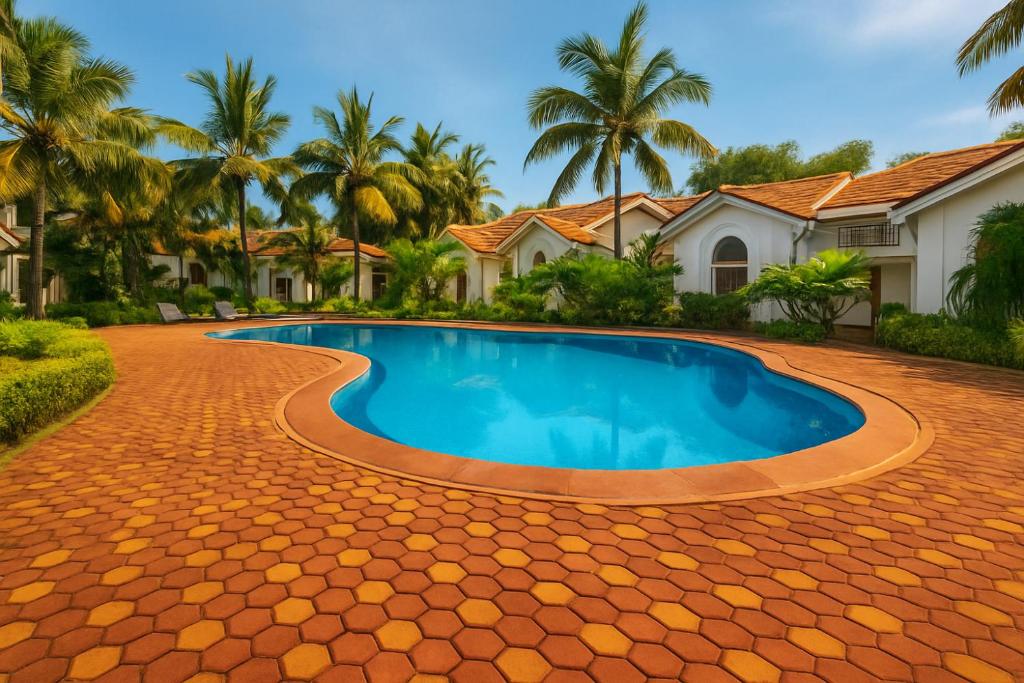 a swimming pool in front of a house with palm trees at Riviera Hermitage in Arpora