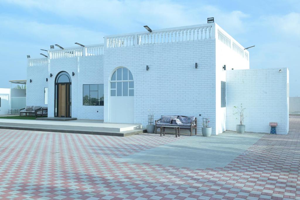 a white brick building with a bench in front of it at Al Miqyal Resort - استراحة المقيال - الساد in Al Ain