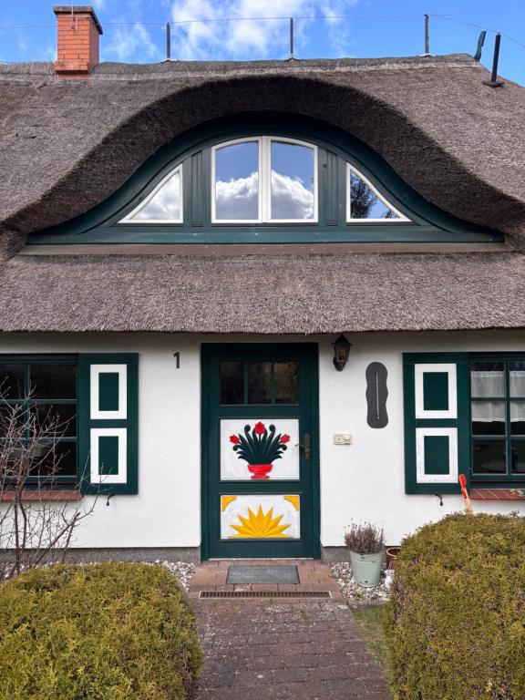 a house with a thatched roof at Alte Fischerhütte Darss in Wieck