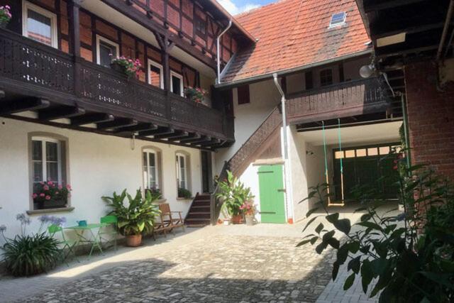 a courtyard of a building with a green door at Altes Kontor in Bad Sulza
